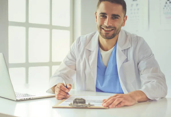 Männlicher Arzt sitzt mit Laptop am Schreibtisch — Stockfoto