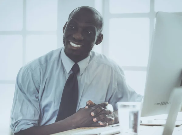 Empresário afro-americano no fone de ouvido trabalhando em seu laptop — Fotografia de Stock