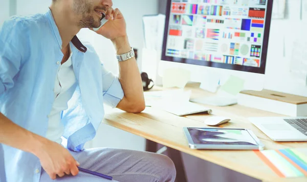 Porträt eines jungen Designers, der im Grafikstudio vor Laptop und Computer sitzt, während er online arbeitet. — Stockfoto