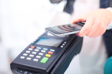 Müşteri ile smartphone Nfc teknolojisi kullanılarak dükkanda ödüyor. NFC teknolojisi. Müşteri ödeme
