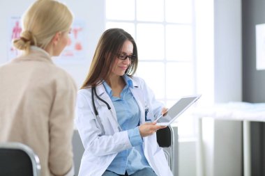 Doktor ve hasta masada otururken bir şey tartışıyorlar. İlaç ve sağlık hizmetleri kavramı