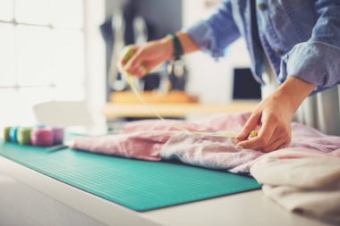 Moda tasarımcısı kadın stüdyoda tasarımları üzerinde çalışıyor.