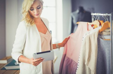 Moda tasarımcısı kadın stüdyoda tasarımları üzerinde çalışıyor.