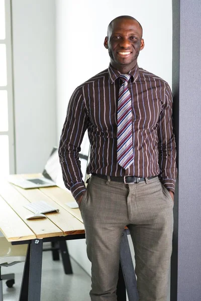 Porträtt av en stilig svart affärsman stående i ämbetet — Stockfoto