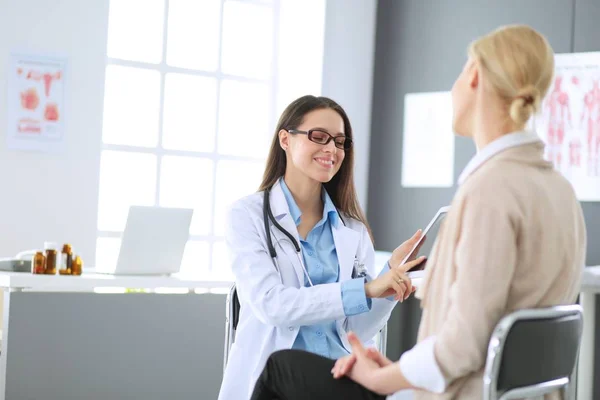 Médico e paciente discutindo algo enquanto se senta na mesa. Conceito de medicina e cuidados de saúde — Fotografia de Stock