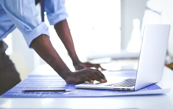 Arquitecto afroamericano trabajando con computadoras y planos en la oficina —  Fotos de Stock