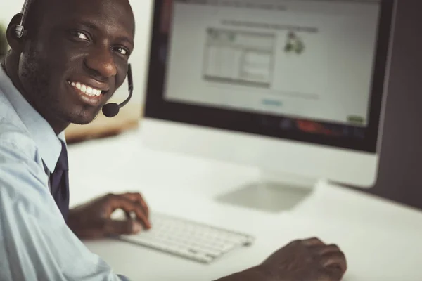 African american businessman on headset working on his laptop — Stock Photo, Image