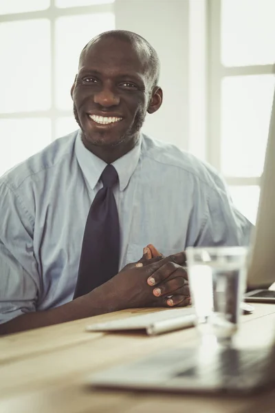 Hombre de negocios afroamericano con auriculares trabajando en su computadora portátil — Foto de Stock