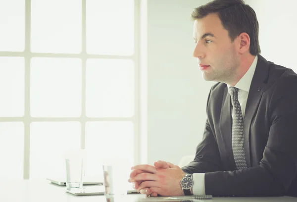 Portrait de jeune homme assis à son bureau dans le bureau. — Photo