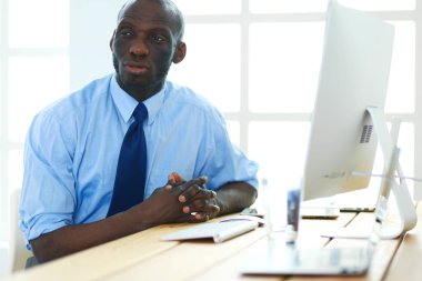 Kulaklıklı Afro-Amerikan işadamı laptopuyla çalışıyor.