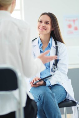 Doktor ve hasta masada otururken bir şey tartışıyorlar. İlaç ve sağlık hizmetleri kavramı