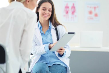 Doktor ve hasta masada otururken bir şey tartışıyorlar. İlaç ve sağlık hizmetleri kavramı