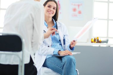 Doktor ve hasta masada otururken bir şey tartışıyorlar. İlaç ve sağlık hizmetleri kavramı