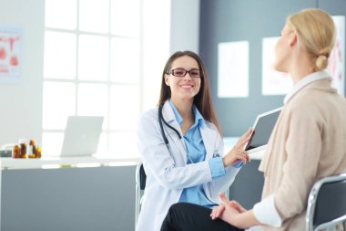 Doktor ve hasta masada otururken bir şey tartışıyorlar. İlaç ve sağlık hizmetleri kavramı