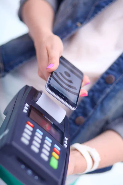 El cliente está pagando con el teléfono inteligente en la tienda utilizando la tecnología NFC. Tecnología NFC. Cliente está pagando —  Fotos de Stock