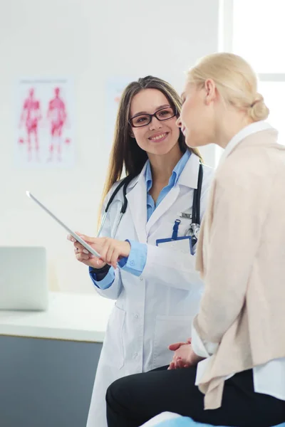 Doktorn och patienten diskuterar något när de sitter vid bordet. Medicin och hälsovård — Stockfoto