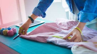 Moda tasarımcısı kadın stüdyoda tasarımları üzerinde çalışıyor.