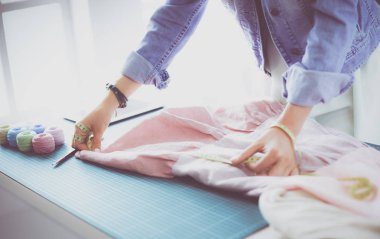 Moda tasarımcısı kadın stüdyoda tasarımları üzerinde çalışıyor.