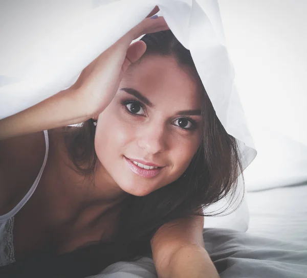 Ung vacker kvinna liggande i sängen under täckmantel — Stockfoto