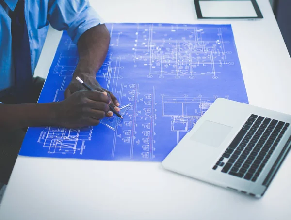 Arquitecto afroamericano trabajando con computadoras y planos en la oficina —  Fotos de Stock