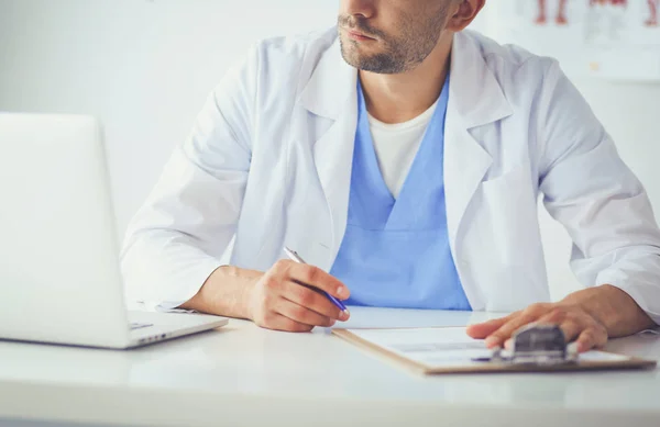 Porträt eines männlichen Arztes mit Laptop am Schreibtisch in der Arztpraxis — Stockfoto