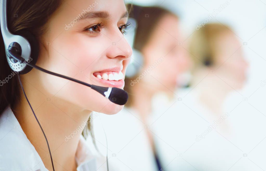 Smiling businesswoman or helpline operator with headset and computer at office