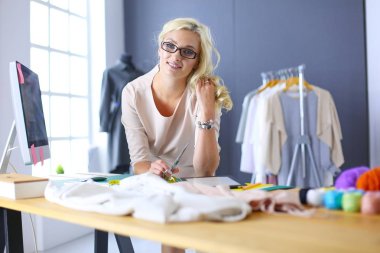 Moda tasarımcısı kadın stüdyoda tasarımları üzerinde çalışıyor..