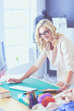 Moda tasarımcısı kadın stüdyoda tasarımları üzerinde çalışıyor..