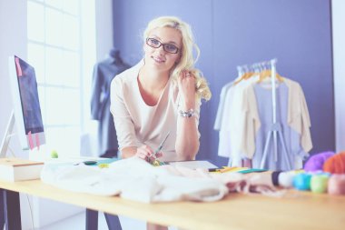 Moda tasarımcısı kadın stüdyoda tasarımları üzerinde çalışıyor..