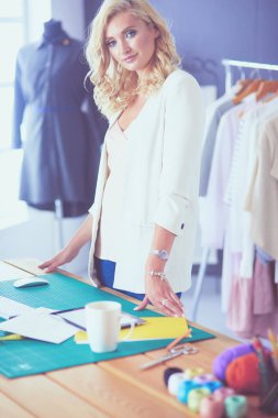 Moda tasarımcısı kadın stüdyoda tasarımları üzerinde çalışıyor..