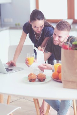 Çift evde mutfak içinde laptop ile onların fatura ödeme