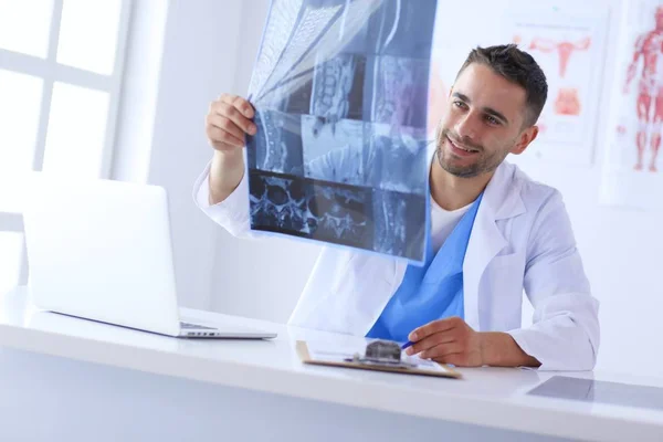 Yakışıklı doktor genç bayan hastasıyla konuşuyor ve ofisinde otururken notlar alıyor.. — Stok fotoğraf