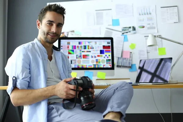 Porträt eines jungen Designers, der im Grafikstudio vor Laptop und Computer sitzt, während er online arbeitet. — Stockfoto