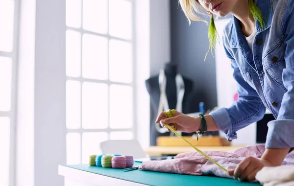 Mulher designer de moda trabalhando em seus projetos no estúdio — Fotografia de Stock