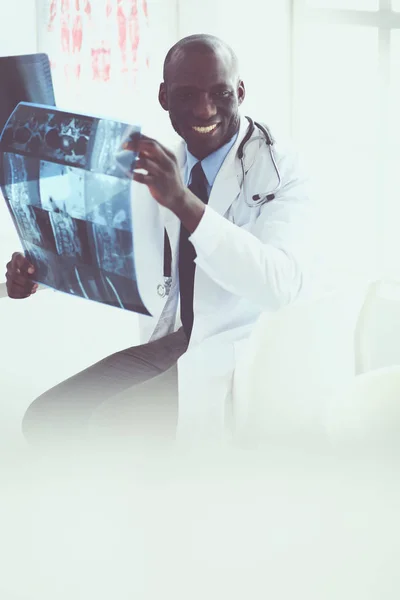Genç Afrikalı doktor portresi hastaların röntgenlerini tutuyor. — Stok fotoğraf