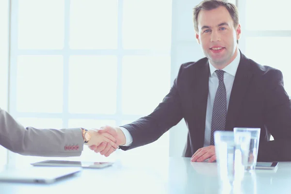 Porträt eines jungen Mannes, der an seinem Schreibtisch im Büro sitzt. — Stockfoto