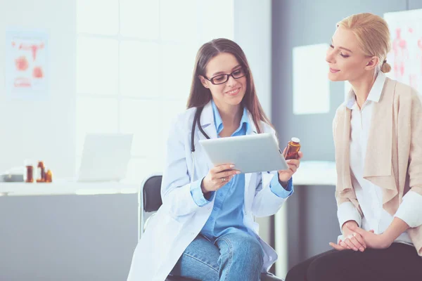 Doktor ve hasta masada otururken bir şey tartışıyorlar. İlaç ve sağlık hizmetleri kavramı — Stok fotoğraf