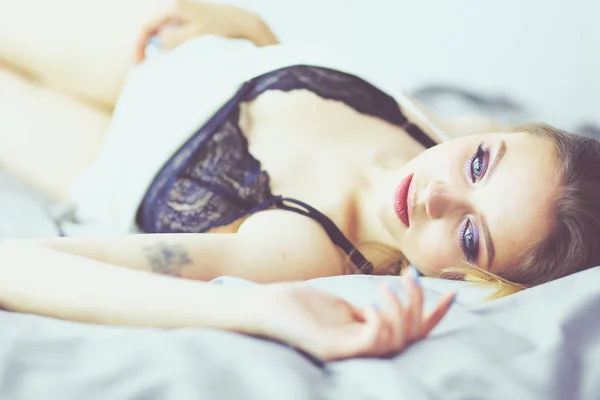 Portret sexy modieuze vrouw op het bed — Stockfoto
