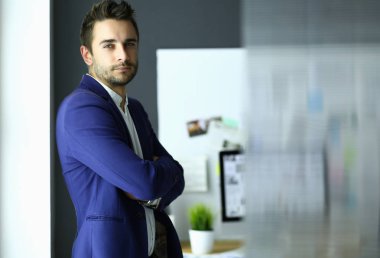 Dizüstü bilgisayar ve bilgisayar çalışırken önünde genç tasarımcı portresi.