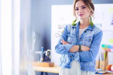 Moda tasarımcısı kadın stüdyoda tasarımları üzerinde çalışıyor.