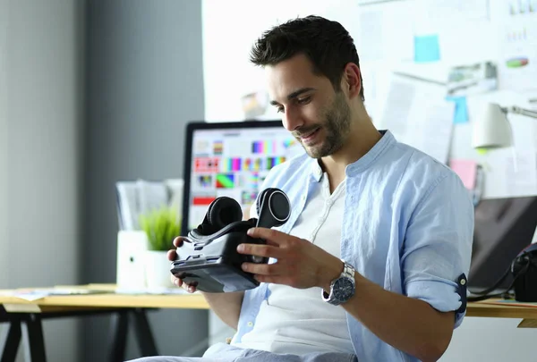 Young male software programmer testing a new app with 3d virtual reality glasses in office.