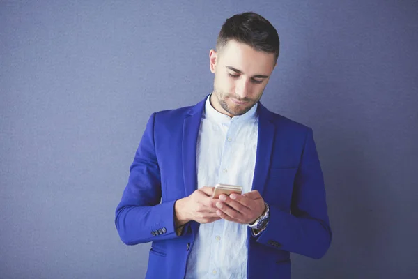 Joven empresario sentado aislado sobre fondo gris. —  Fotos de Stock