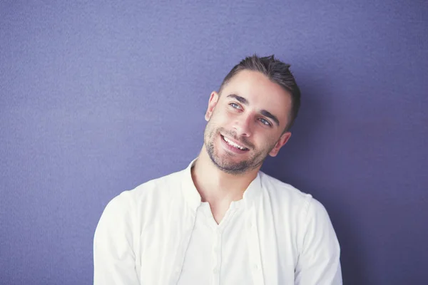 Young businessman sitting isolated on grey background. — Stock Photo, Image