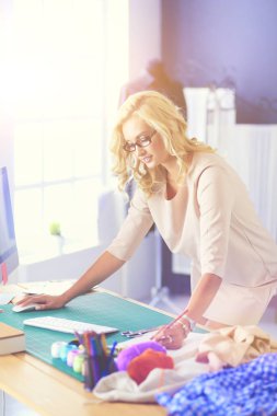 Moda tasarımcısı kadın stüdyoda tasarımları üzerinde çalışıyor..