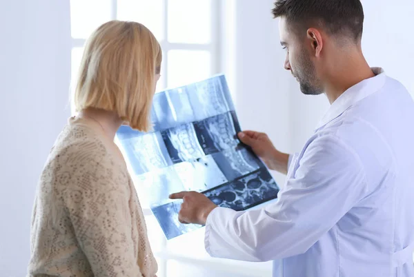 Guapo médico está hablando con una joven paciente y haciendo — Foto de Stock