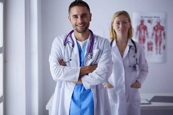 Bello medico sta parlando con giovane medico femminile e fare n — Foto Stock