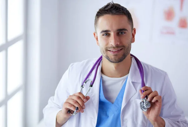 Mladý a sebevědomý mužský lékař portrét stojící v lékařské off — Stock fotografie