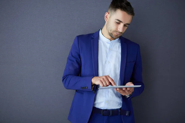 Ung affärsman sitter isolerad på grå bakgrund. — Stockfoto