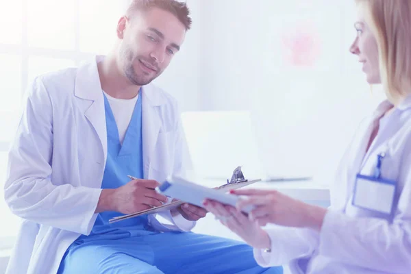 Handsome doctor is talking with young female doctor and making n — Stock Photo, Image