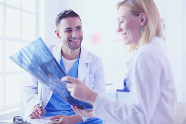 Schöner Doktor spricht mit jungen Ärztin und macht n — Stockfoto